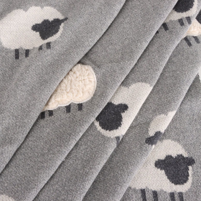 Folded fabric with sheep pattern on a gray background