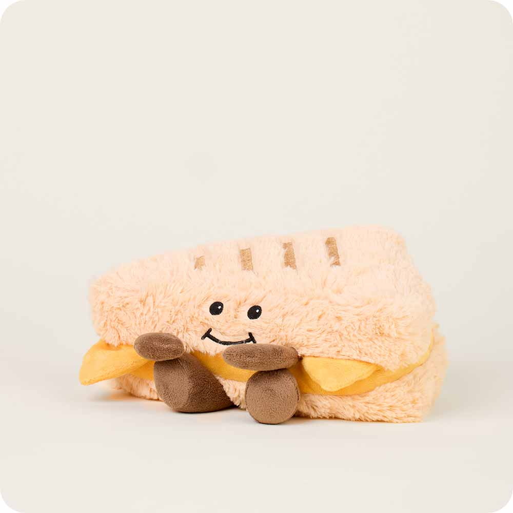 Plush toy resembling a sandwiche with a smiley face on a white background