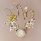 Small round bag with floral design, yellow flower accessory, and hair accessories on a beige background.
