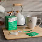 Earth Mama Organic Peaceful Tea packaging with a mug and tea bags on a wooden board.