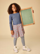 Child holding a small chalkboard with a neutral background