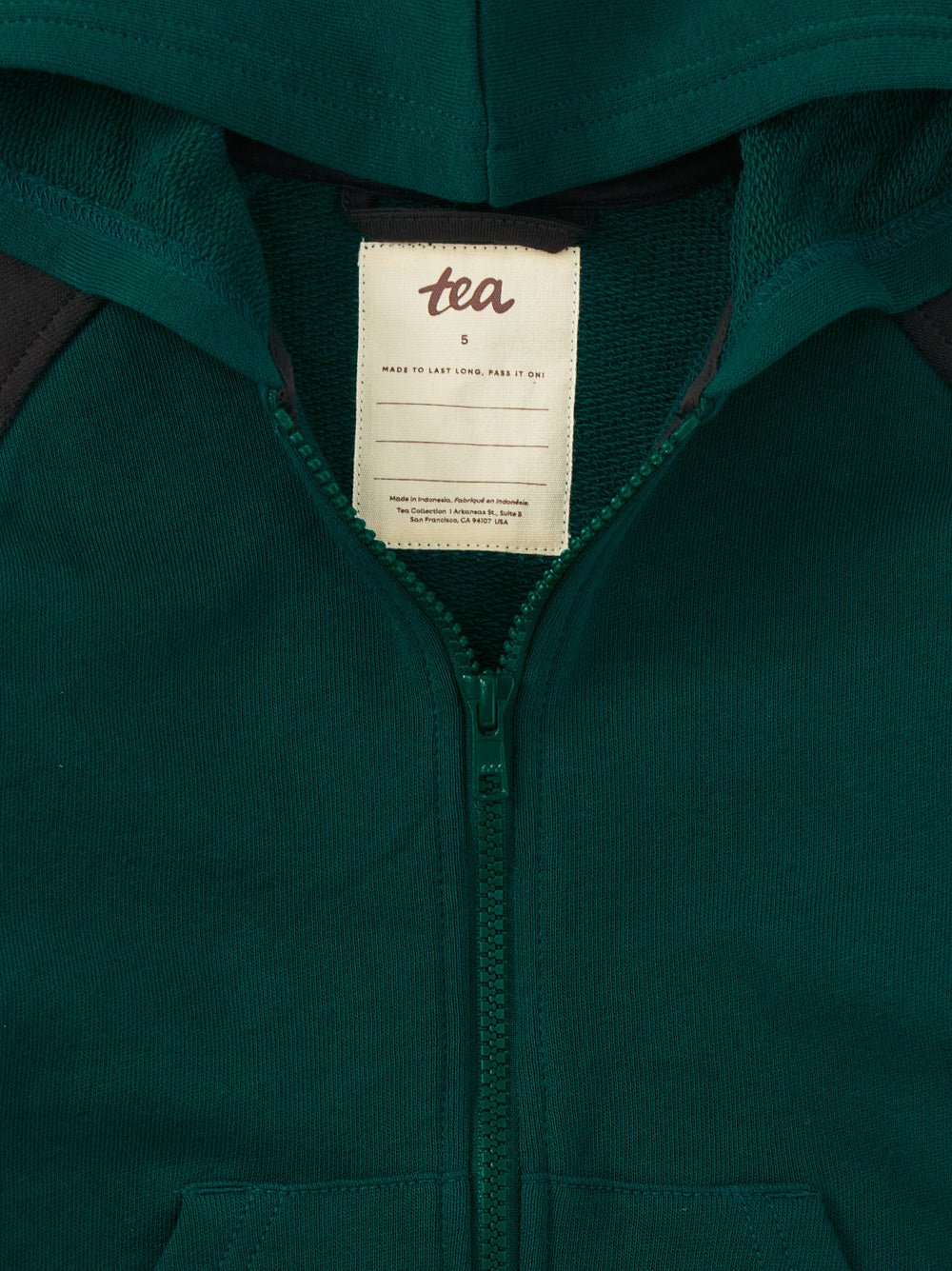 Close-up of a green hoodie with a visible brand tag.