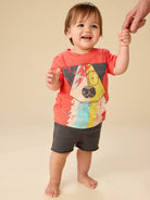 Child wearing a colorful t-shirt with a dog design on a beige background