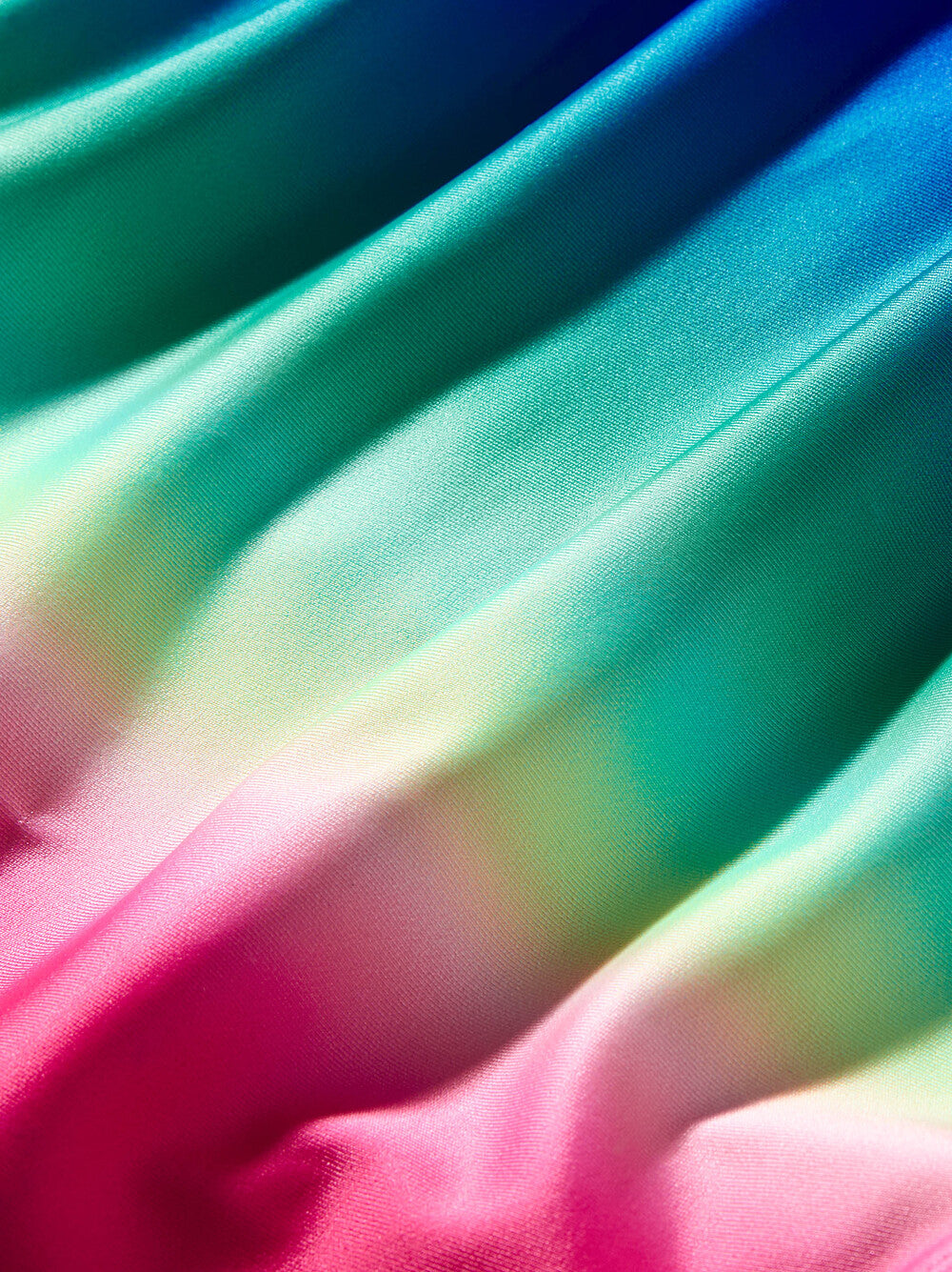 Close-up of colorful fabric with a gradient from blue to pink.