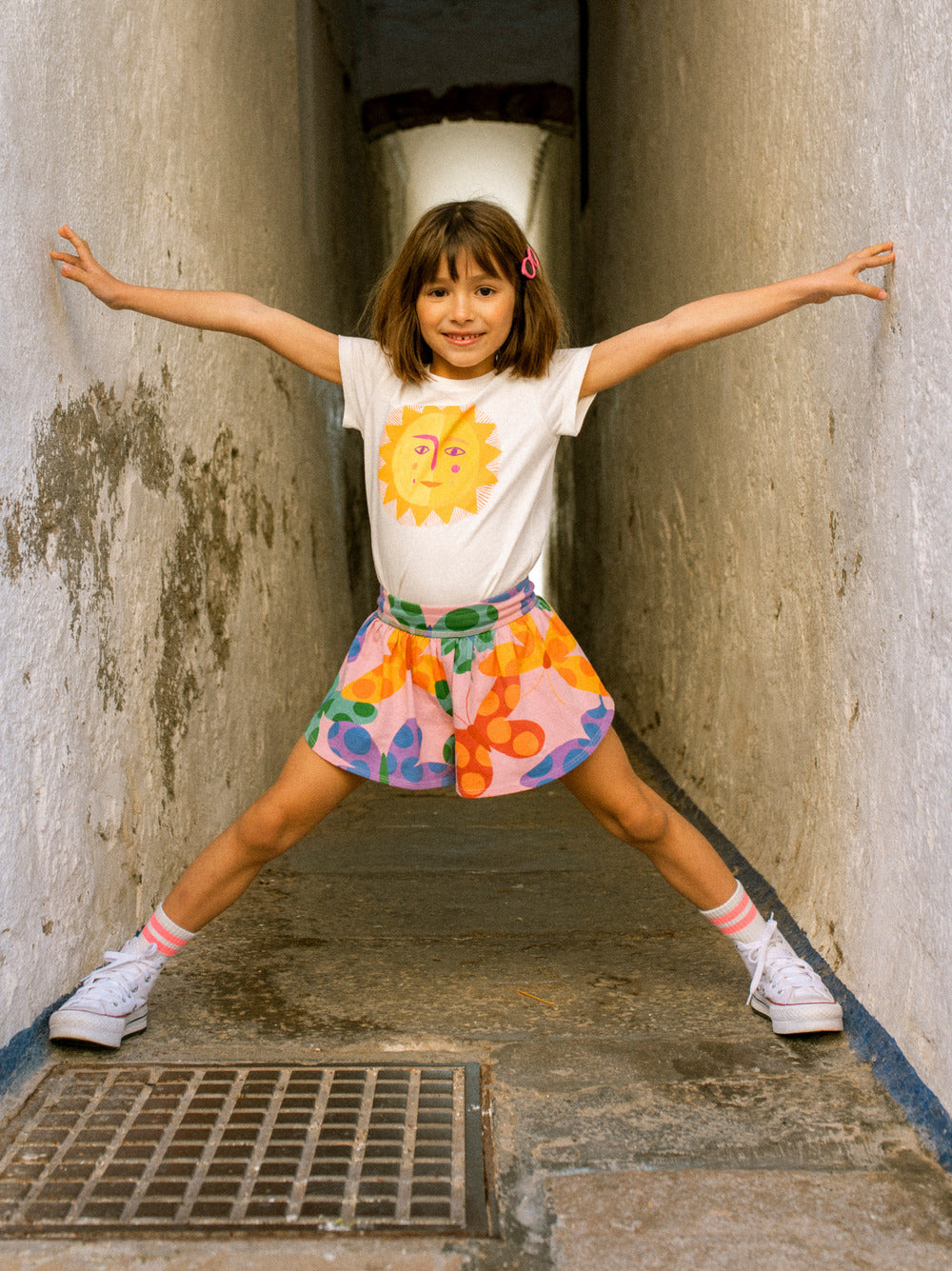 Child in a colorful outfit standing in a narrow alleyway