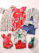 Collection of children's clothing including dresses, shirts, shorts, and a bag on a light background