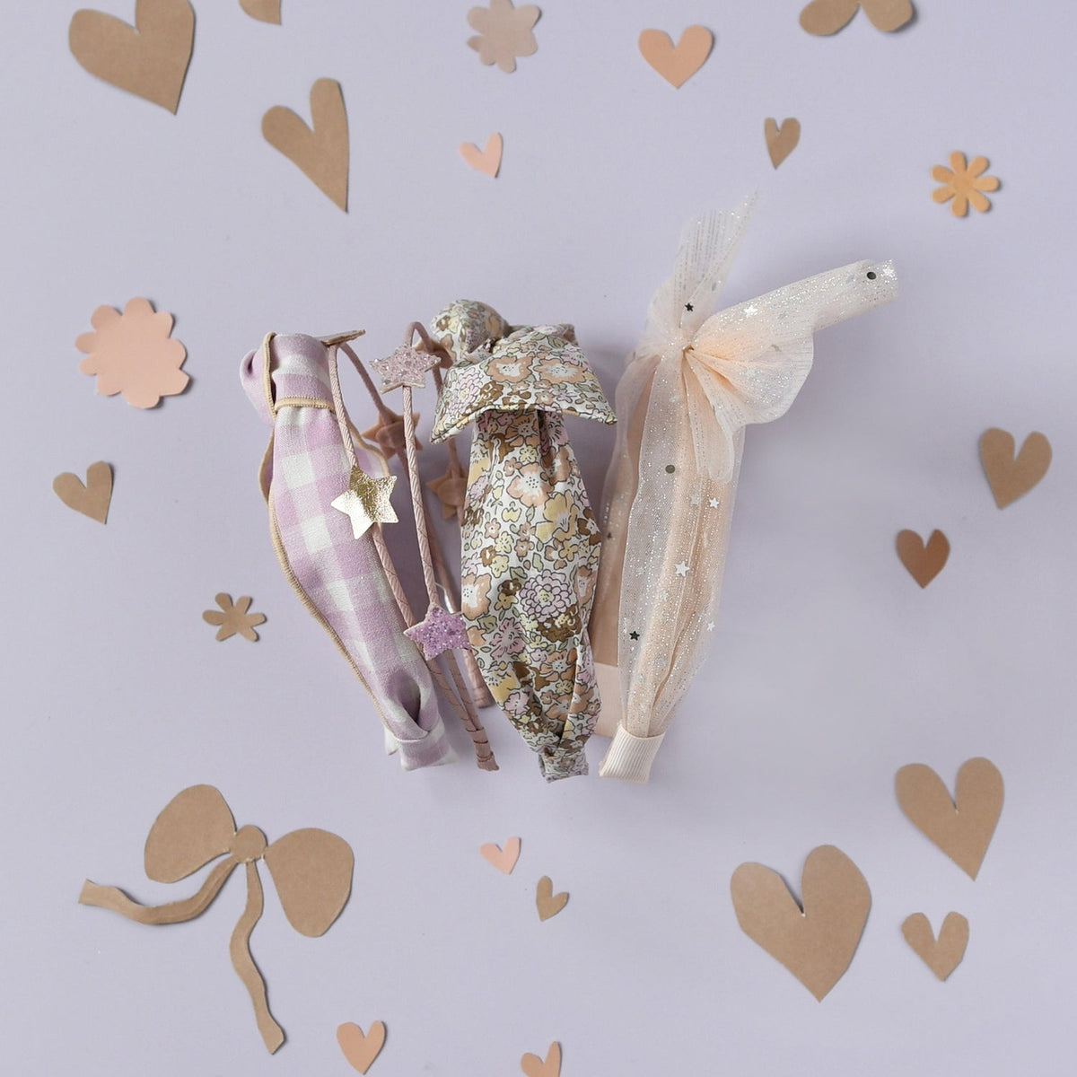 Three decorative items on a light purple background with heart shapes