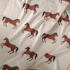 Fabric with brown horse pattern on a beige background