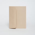 Two beige notebooks stacked on a white background