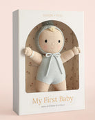 A knitted baby doll with a pale peach face and limbs, wearing a light blue knit bonnet with a pom-pom and a matching blue knitted romper, shown against a plain white background.