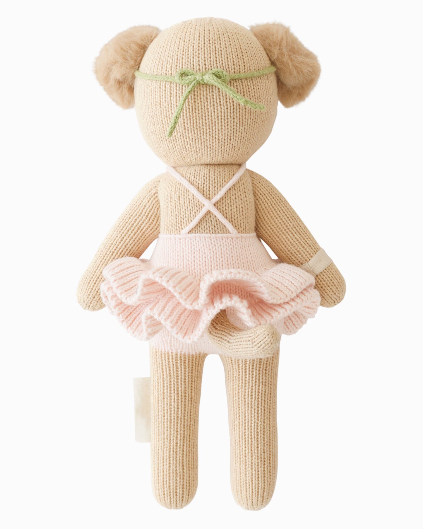 Knitted teddy bear in a pink dress with a white background