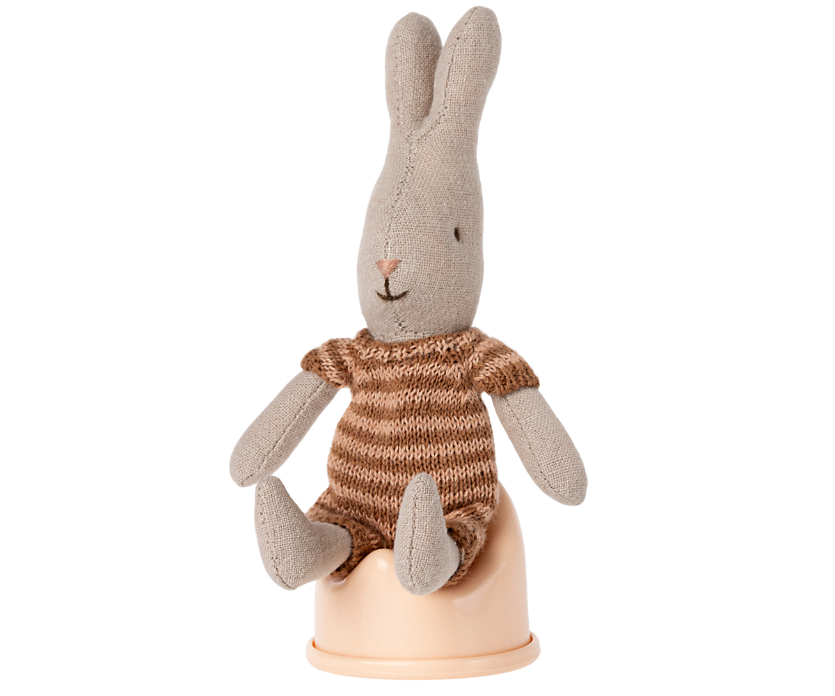 Knitted rabbit toy with a striped sweater on a white background
