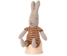 Knitted rabbit toy with a striped sweater on a white background