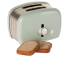 Small mint green toaster with wooden slices on a white background