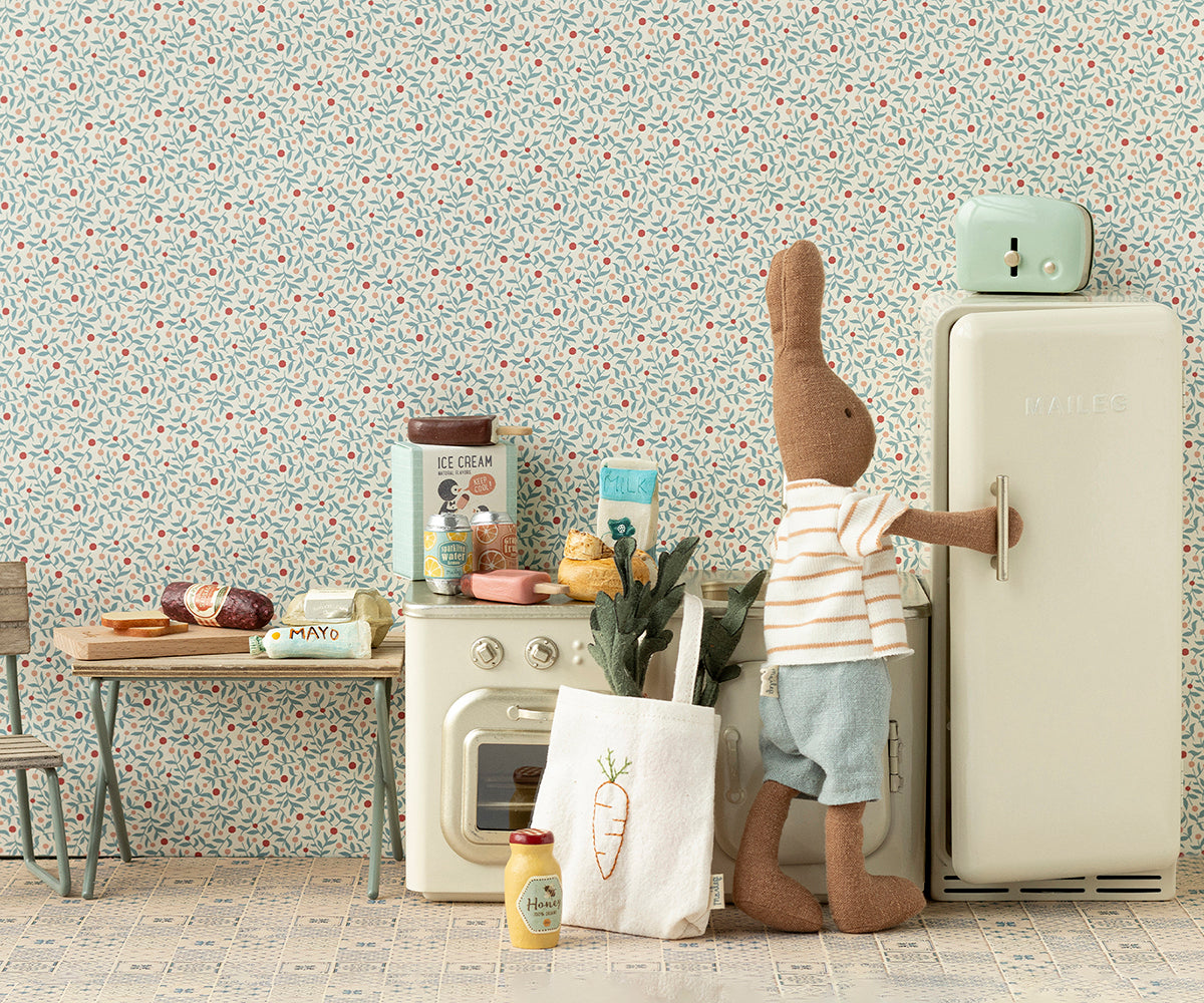 Stuffed toy rabbit opening a refrigerator in a playroom with toys and furniture.
