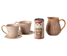 Ceramic mugs, a pitcher, and a chocolate milk container on a white background