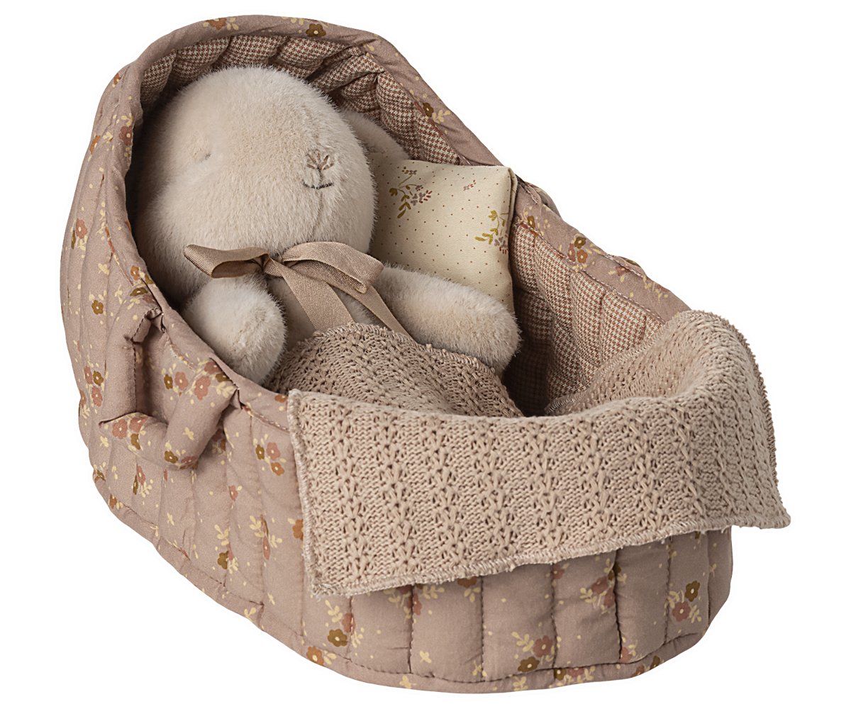 Baby booties in a floral-patterned fabric basket on a white background