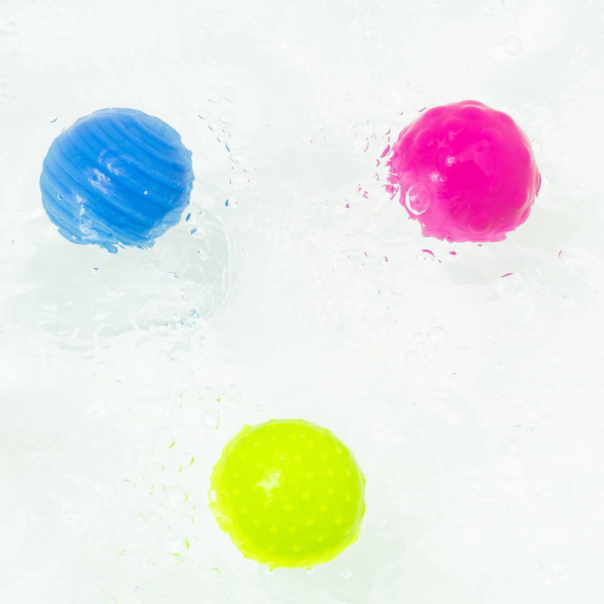 Three colorful gel-like spheres on a white background