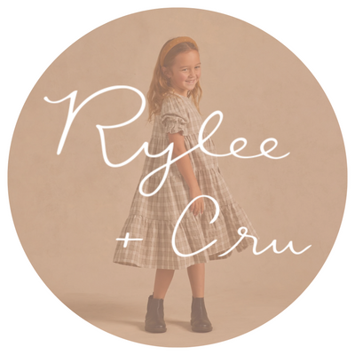 girl in a rylee and cru dress twirling with a rylee and cru logo on top