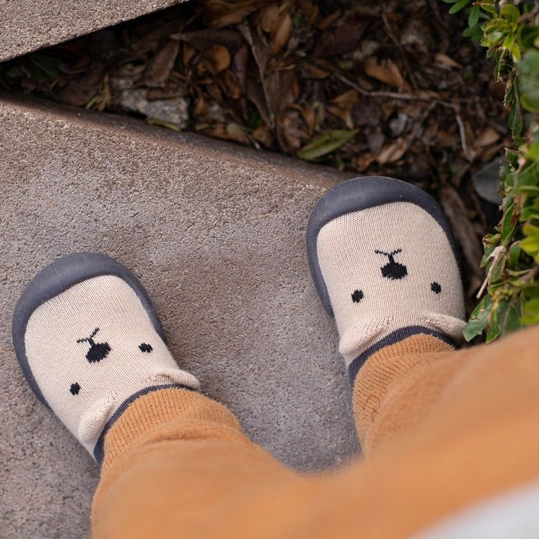 Baby shoes with cartoon design on a stone surface