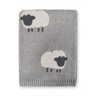 Gray knitted blanket with sheep designs on a white background