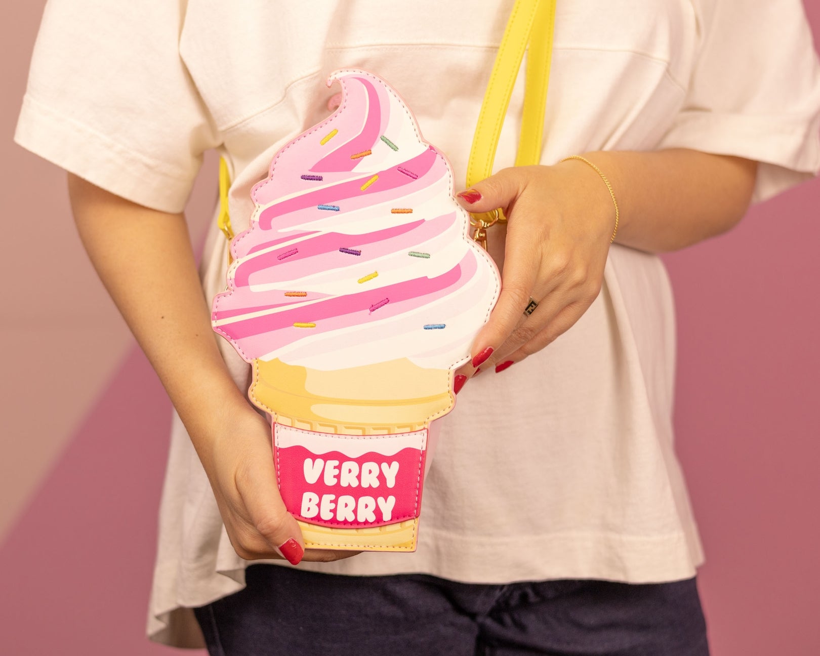 Ice cream-shaped pouch with 'Verry Berry' text held by a person against a pink background