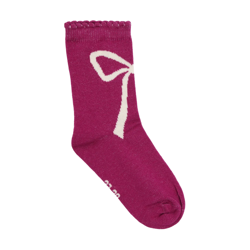 A plum or huckleberry pink sock from the Minymo 3-Pack Socks set (featuring a cute white bow pattern and a wavy ribbed top)