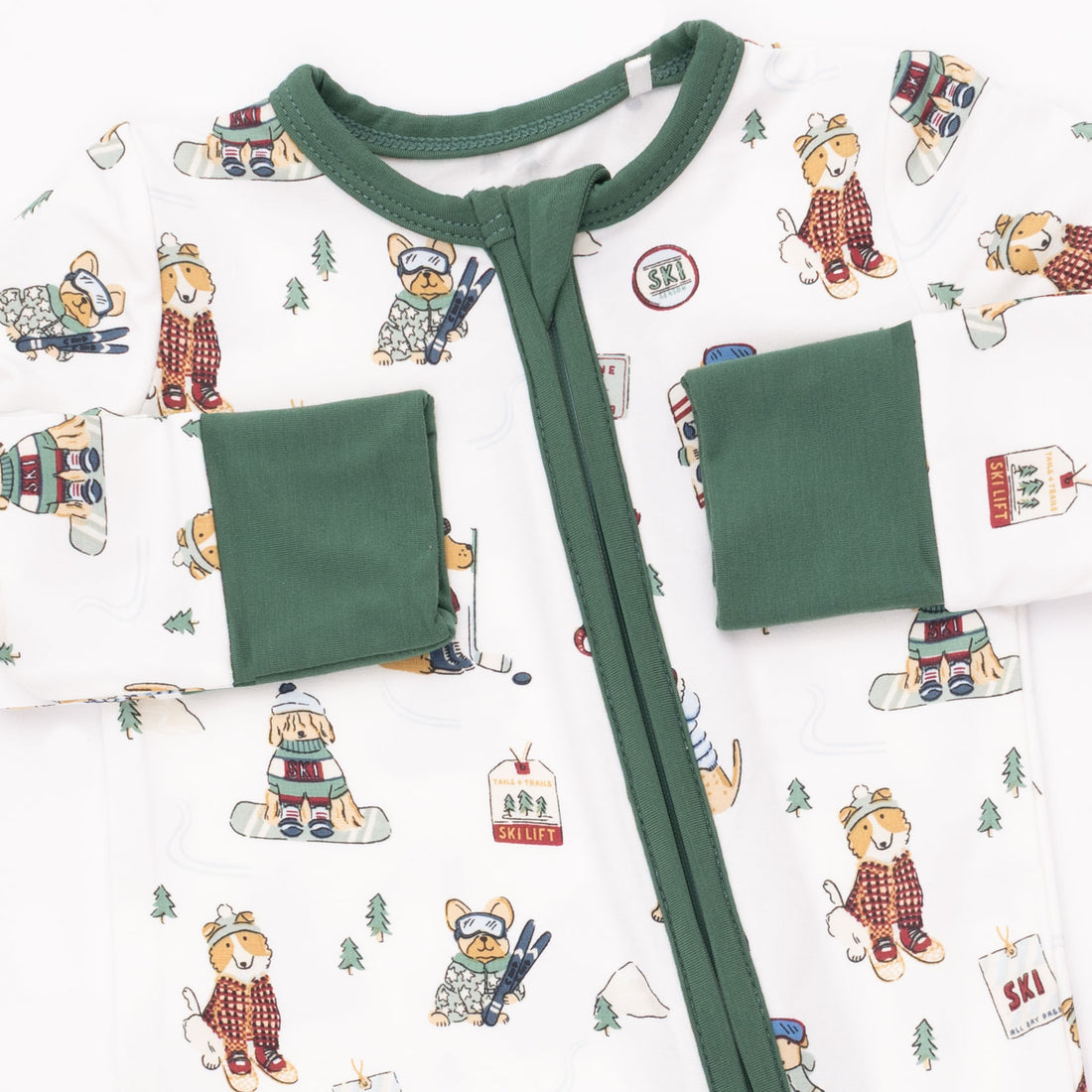 Baby onesie with green trim on a patterned background
