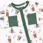 Baby onesie with green trim on a patterned background