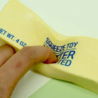 Yellow squeeze toy with text on a white background