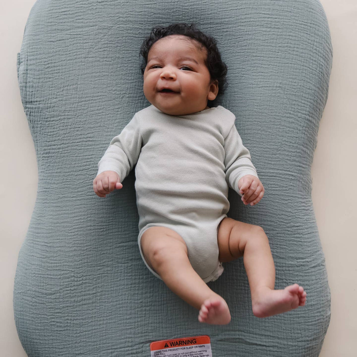 Baby lying on a textured gray pillow