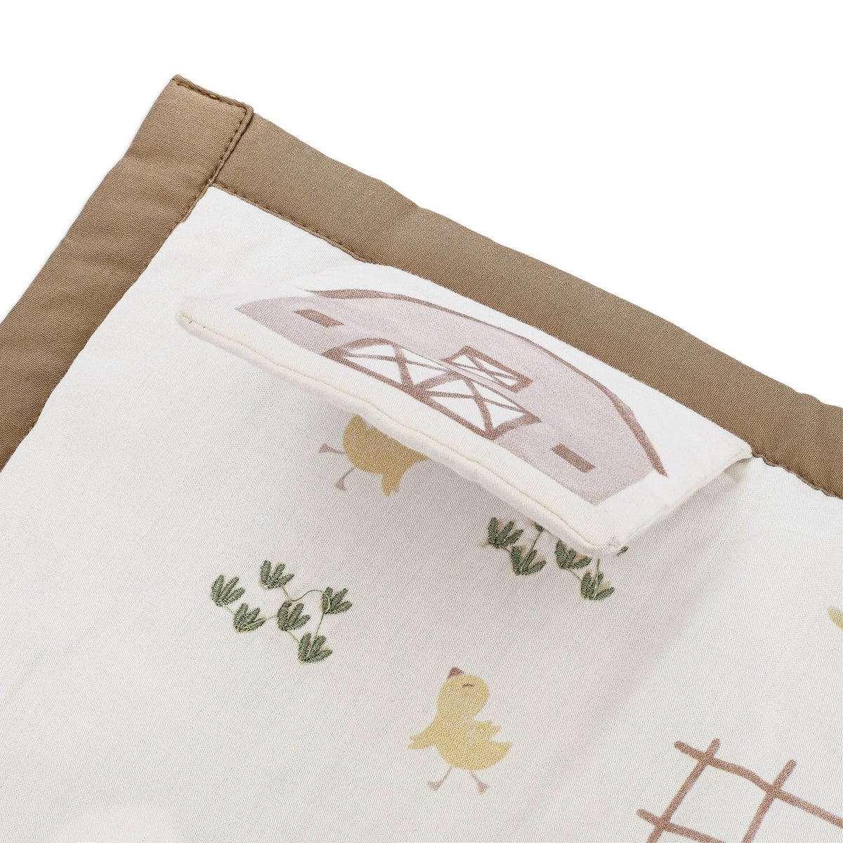 Fabric with embroidered design of a barn, chickens, and plants on a white background.