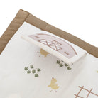 Fabric with embroidered design of a barn, chickens, and plants on a white background.