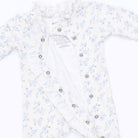 A baby long-sleeve romper in white with a light blue floral print, featuring ruffled trim along the front and a button-down design.