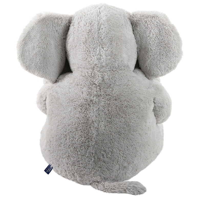 A light gray plush elephant toy shown from the back, featuring soft, textured fur and a small blue brand tag near the tail, set against a plain white background.