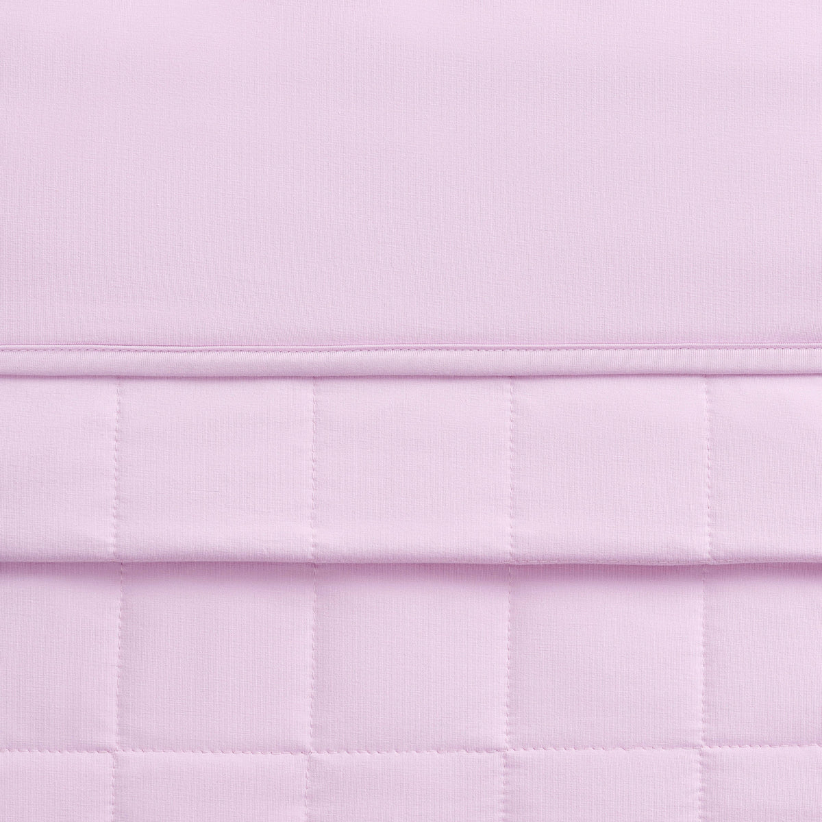 Close-up of a quilted lavender fabric with a checkered pattern.