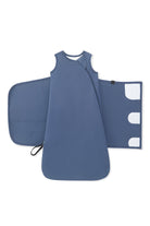 A baby sleep sack in slate blue, shown flat-laid with its matching zippered outer cover and hood visible behind it on a clean white background.