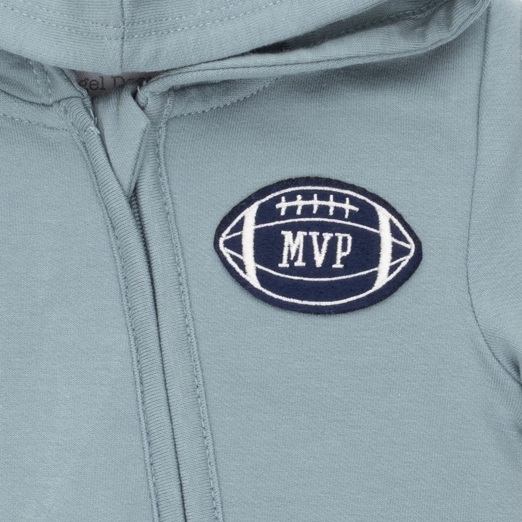 Close-up of a light blue-gray zip-up hoodie with a navy and white embroidered football-shaped MVP patch on the chest.