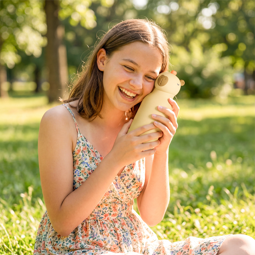 Woman in a floral dress holding a beige ceramic cat figurine in a park