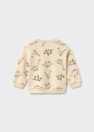 A cream-colored long-sleeve sweatshirt with an all-over green dinosaur print, shown from the back against a light gray background.