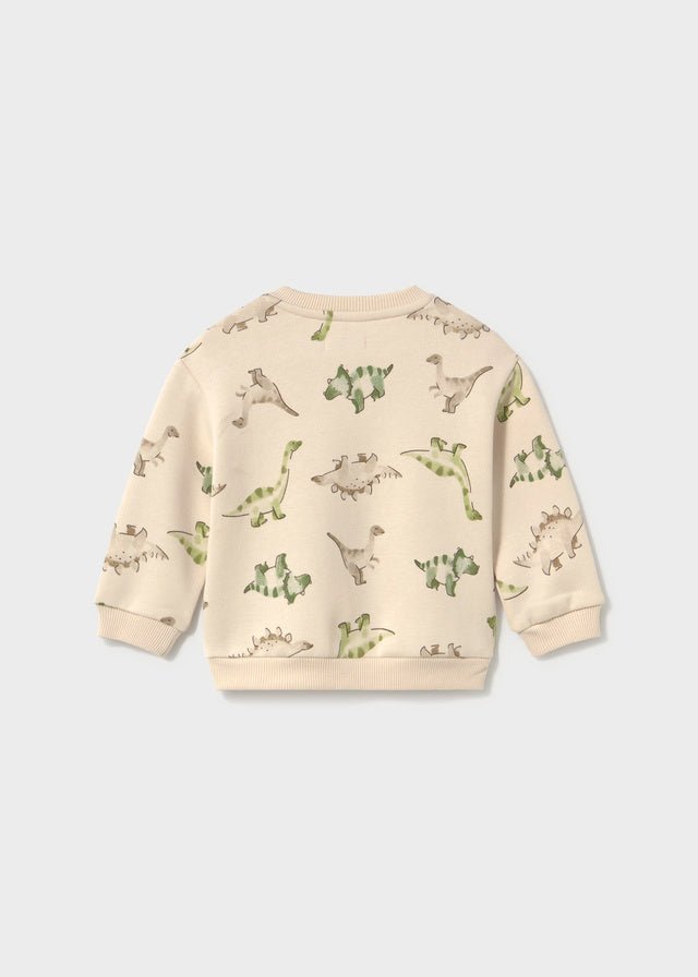 A cream-colored long-sleeve sweatshirt with an all-over green dinosaur print, shown from the back against a light gray background.