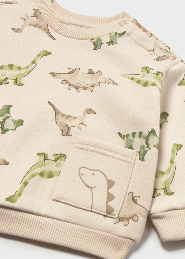 Beige sweater with dinosaur prints on a white background