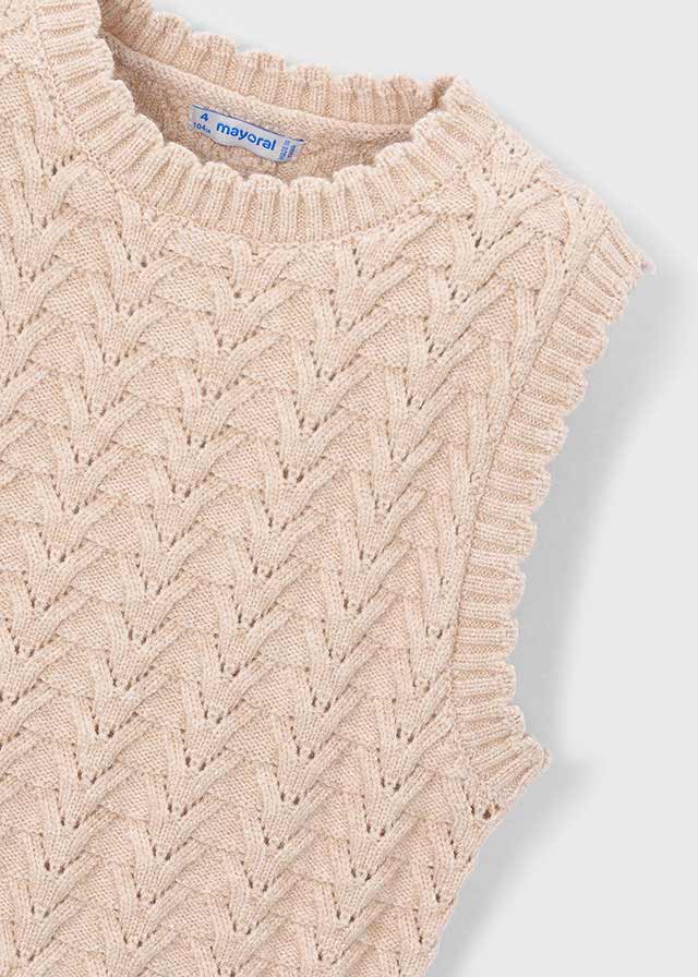 Beige knitted sweater with a textured pattern on a light gray background