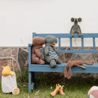 Plush toys on a blue bench outdoors