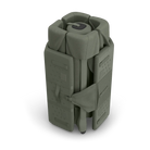 An olive green UPPAbaby Remi V2 Playard folded up in its travel bag on a checkered background.