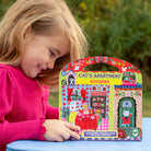 Child holding a 'Cat's Apartment' stickers book with a colorful cover