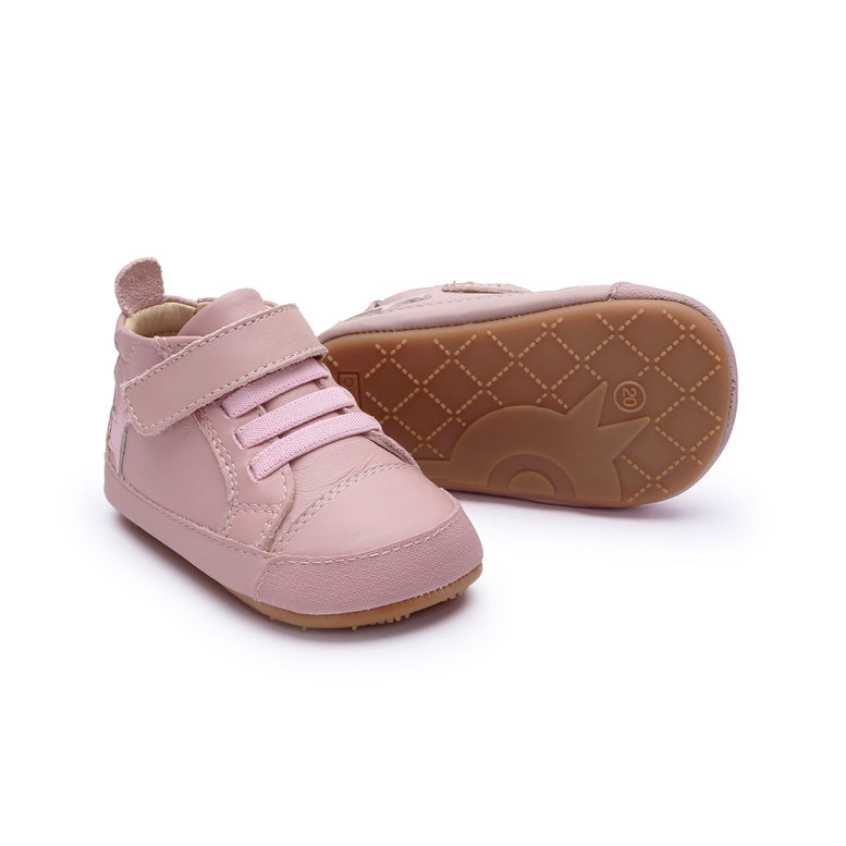 A pair of baby high-top shoes in light pink, featuring a hook-and-loop strap closure and a brown contoured sole, shown on a white background.