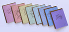 A set of colorful greeting cards arranged in a fan shape on a light background. The cards feature elegant metallic foil script text such as 'Happy Birthday' and 'The Best Years Come Soon.