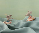 Two plush mouse toys with life vests on a textured surface with a green background