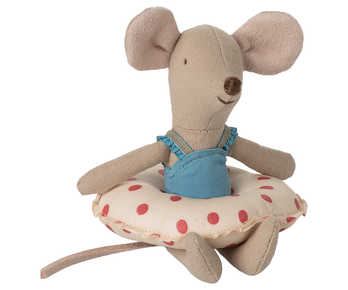 Plush mouse toy with a blue dress sitting on a polka dot cushion against a white background